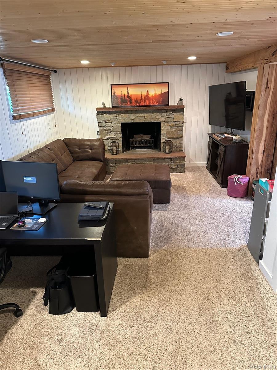 974 Wagon Trail Road Evergreen, CO 80439 - Photo 25 of 45 a living room with furniture and a flat screen tv