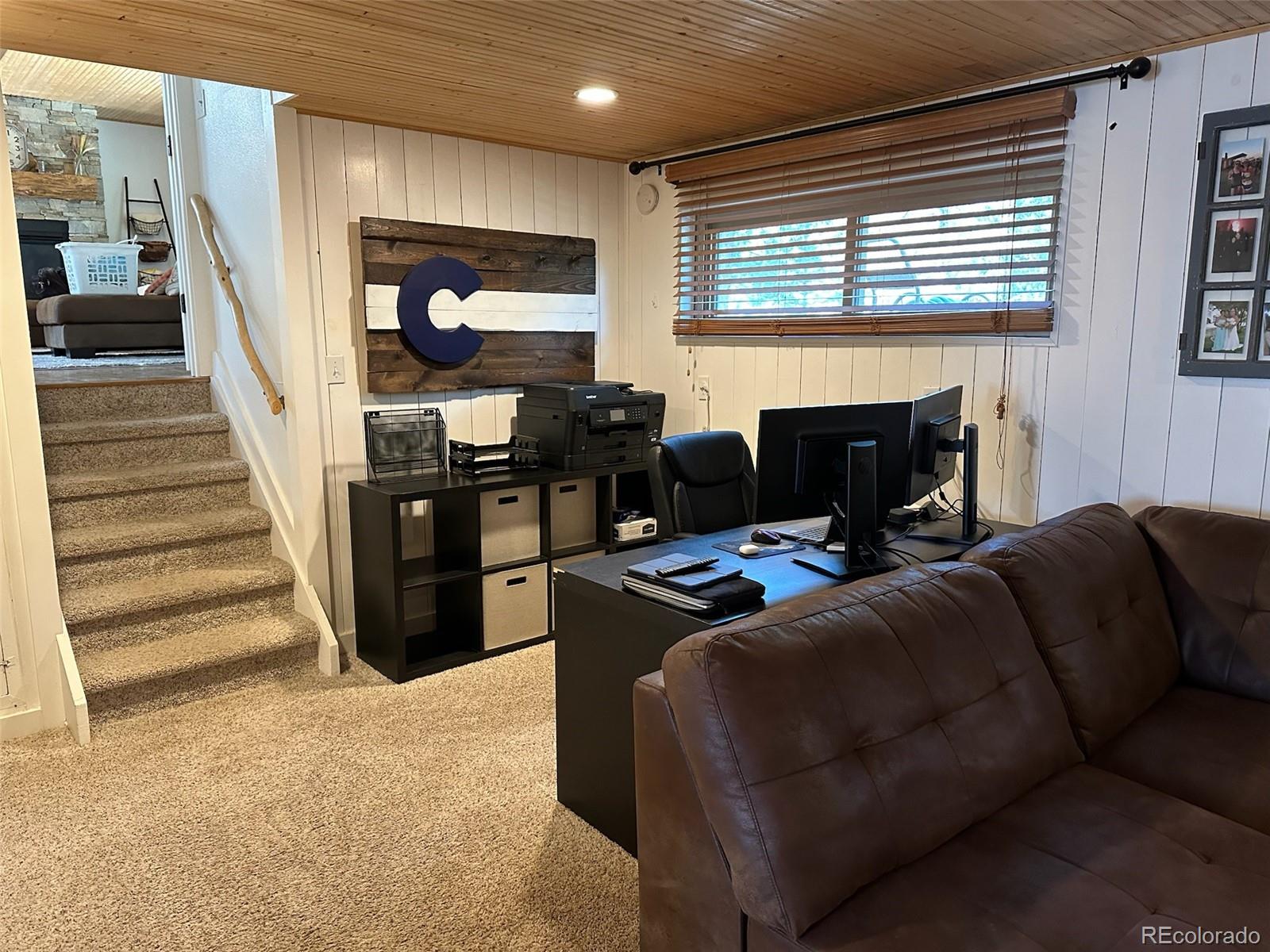 974 Wagon Trail Road Evergreen, CO 80439 - Photo 26 of 45 a living room with furniture a fireplace and a flat screen tv