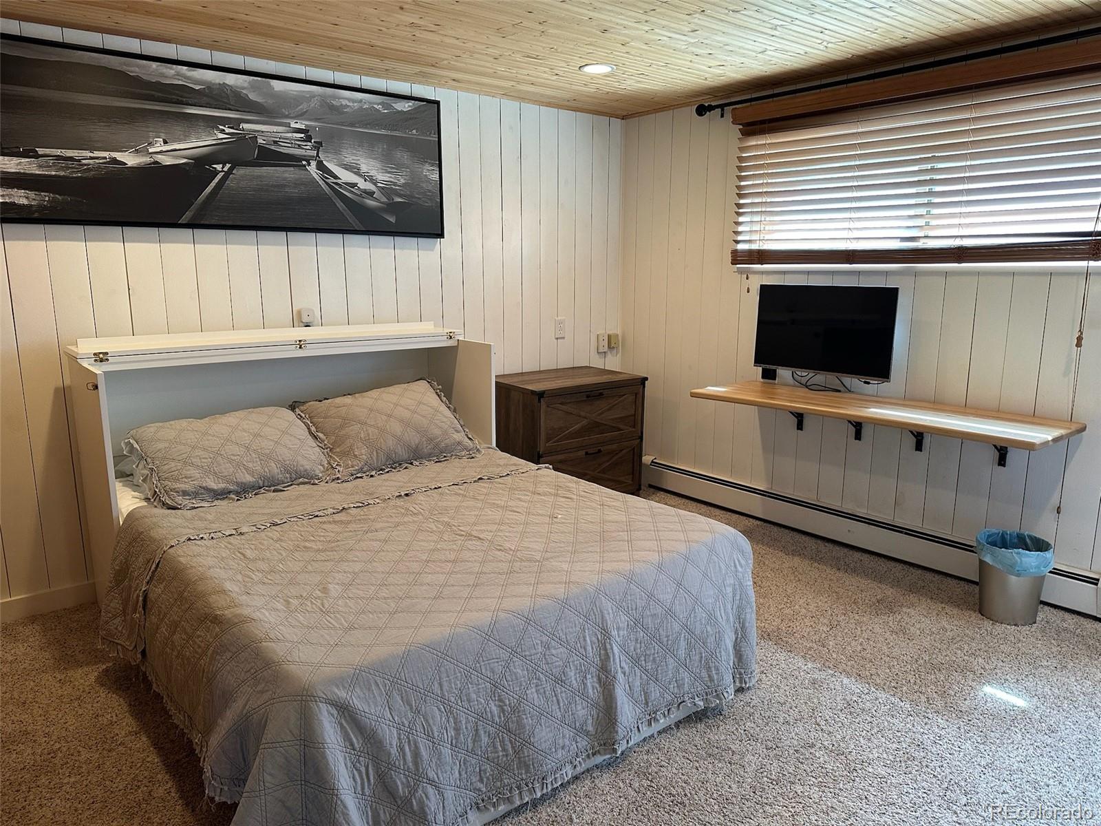 974 Wagon Trail Road Evergreen, CO 80439 - Photo 28 of 45 a bedroom with a bed and a flat screen tv