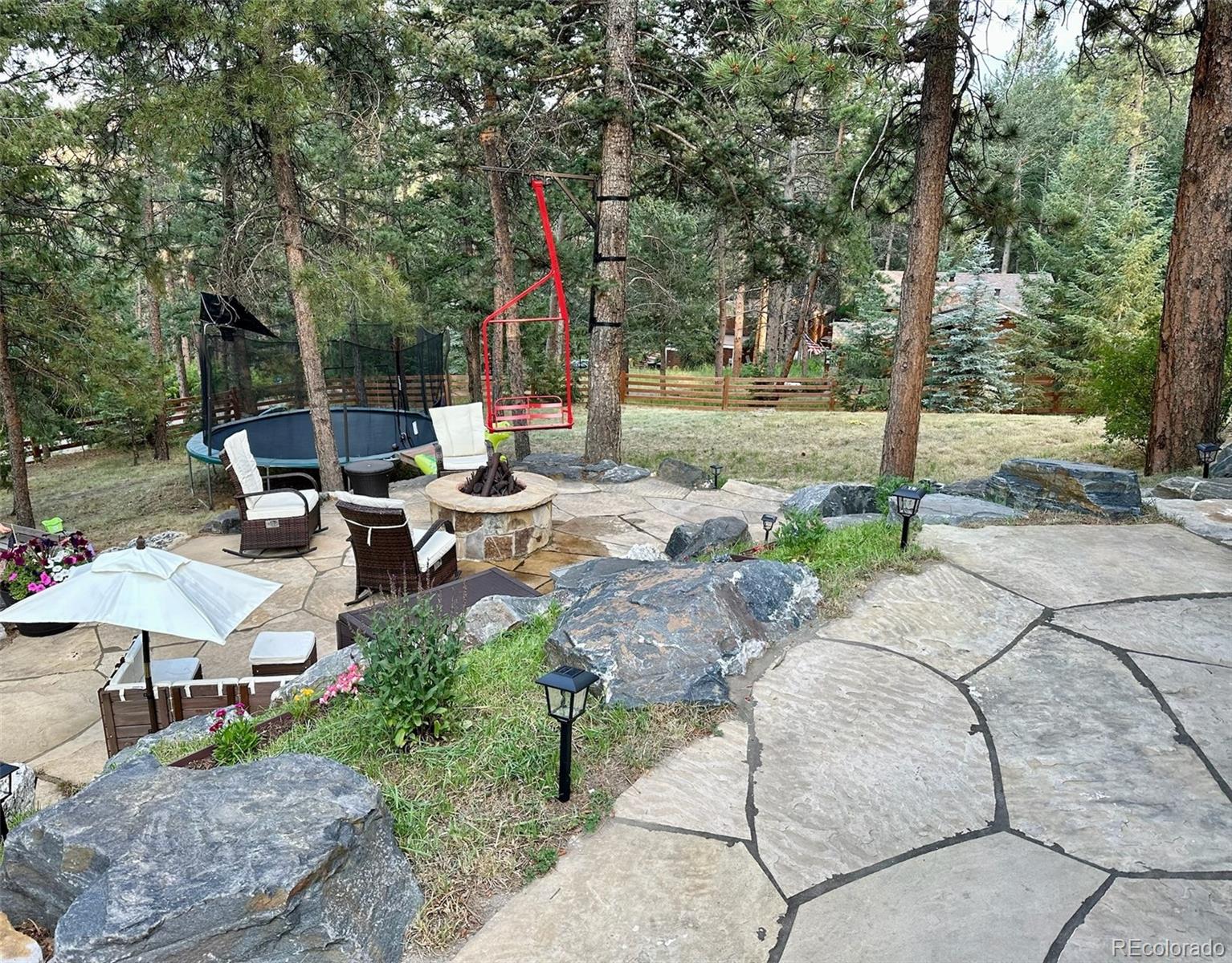 974 Wagon Trail Road Evergreen, CO 80439 - Photo 34 of 45 a backyard of a house with table and chairs