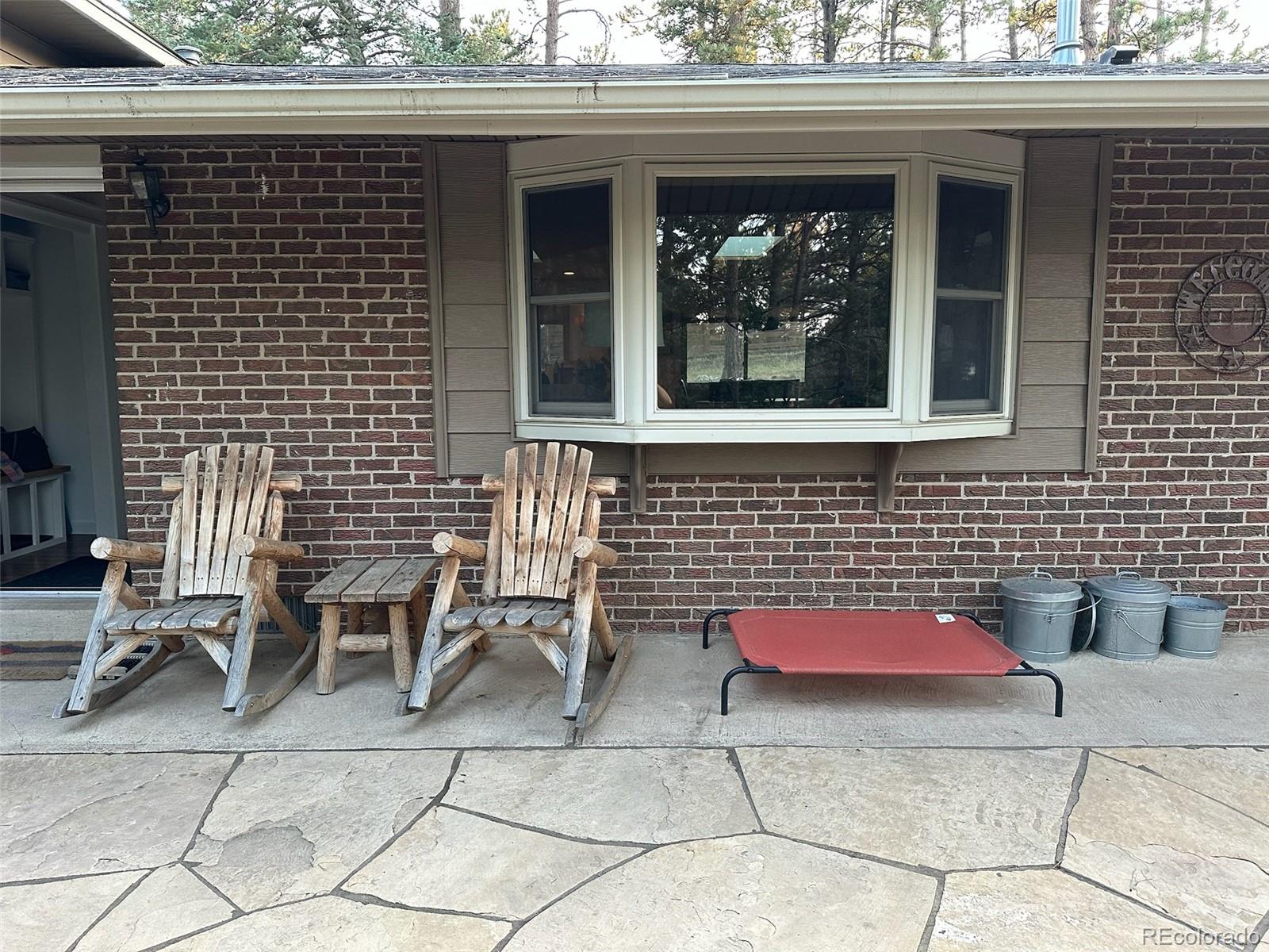 974 Wagon Trail Road Evergreen, CO 80439 - Photo 36 of 45 a front view of a house with outdoor seating