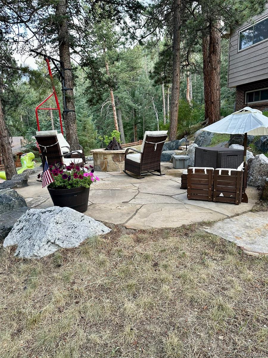 974 Wagon Trail Road Evergreen, CO 80439 - Photo 39 of 45 a view of a backyard with sitting area and furniture