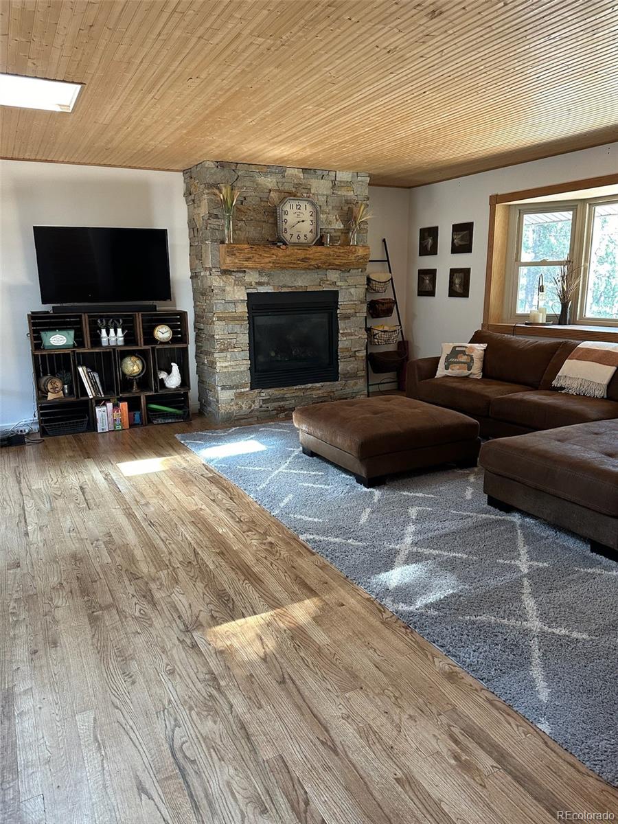 974 Wagon Trail Road Evergreen, CO 80439 - Photo 8 of 45 a living room with furniture and a flat screen tv