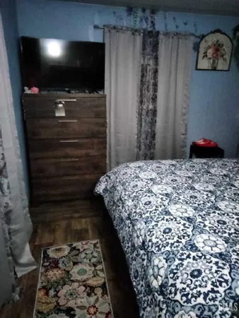 a bedroom with a bed and a flat screen tv