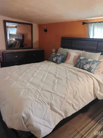 a large bed sitting in a bedroom next to a window