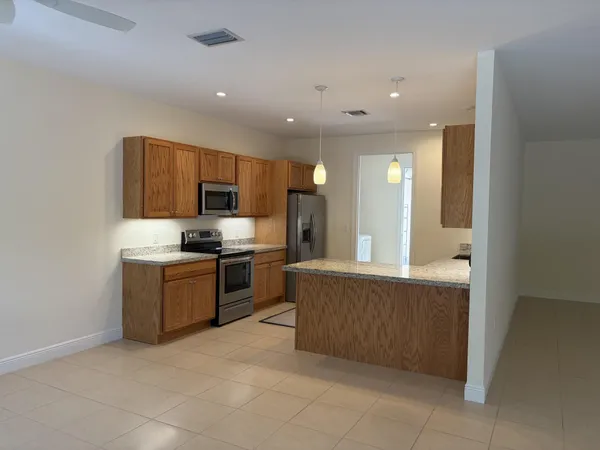 a large kitchen with a large counter top stainless steel appliances and cabinets