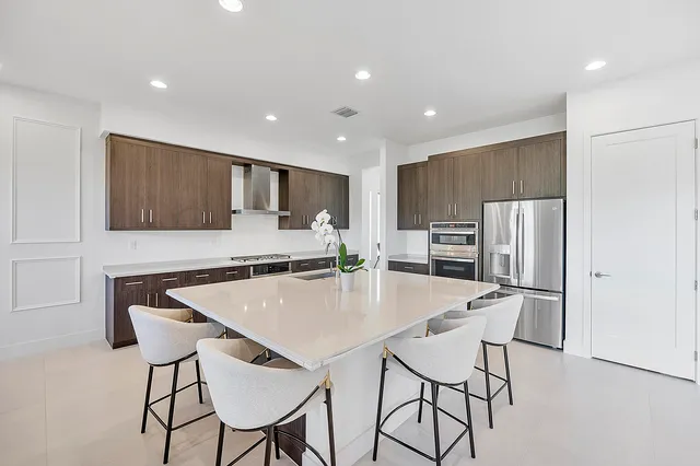 a kitchen with stainless steel appliances granite countertop a sink stove and refrigerator