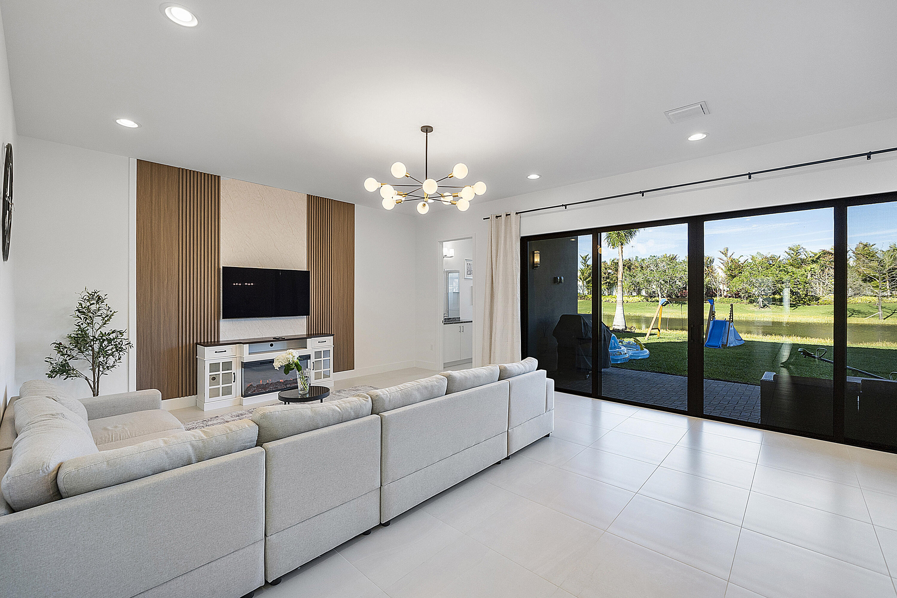 20296 Somerset Hls Drive Boca Raton, FL 33434 - Photo 18 of 67 a living room with furniture large windows and a flat screen tv