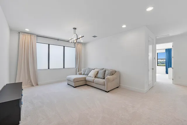 a spacious bedroom with a bed and a chandelier