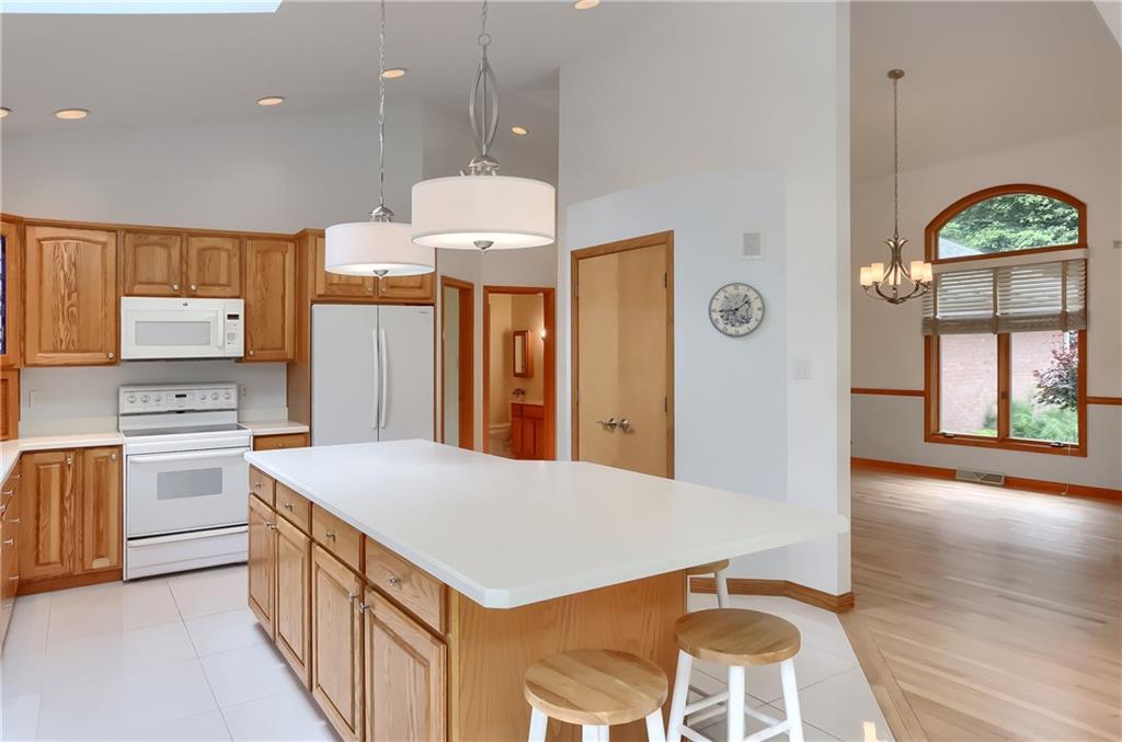 377 Magee Road Sewickley, PA 15143 - Photo 18 of 50 a kitchen with stainless steel appliances a stove a sink a refrigerator and a dining table with wooden floor