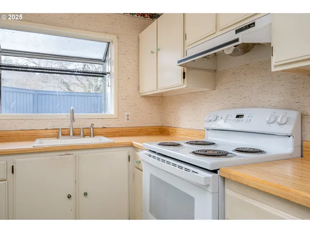 a kitchen with kitchen island a sink stove and cabinets