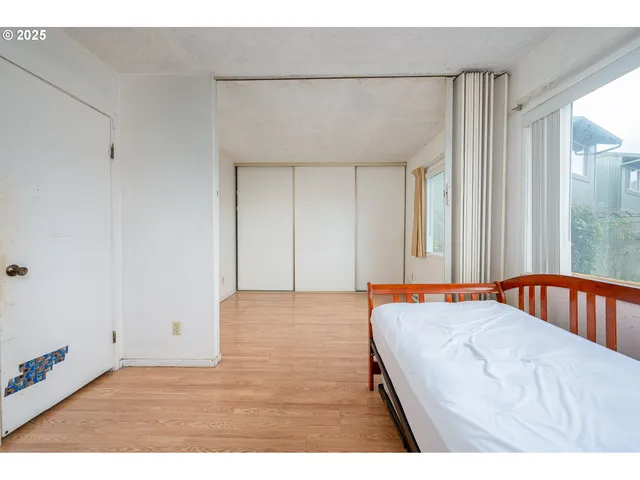 a bedroom with a bed and a large window