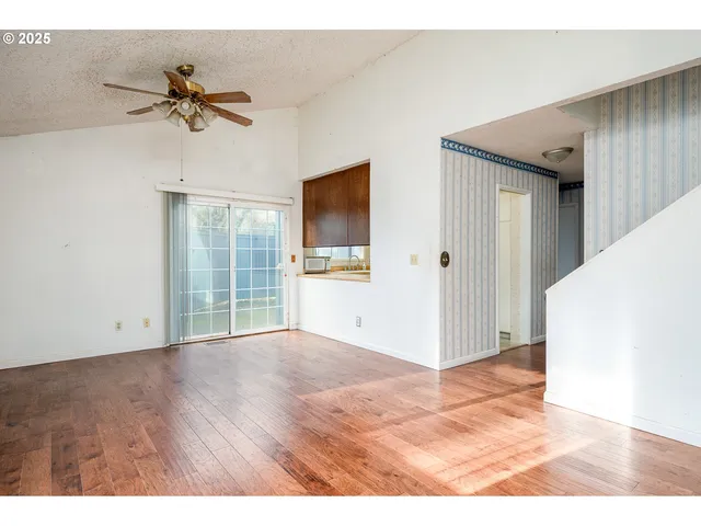 a view interior of a house with wooden floor a ceiling fan and windows