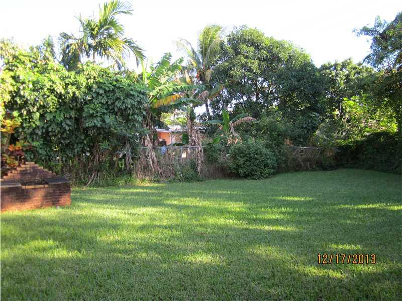 576 Northwest 147th Street Miami, FL 33168 - Photo 2 of 3 a backyard of a house with lots of green space and fountain
