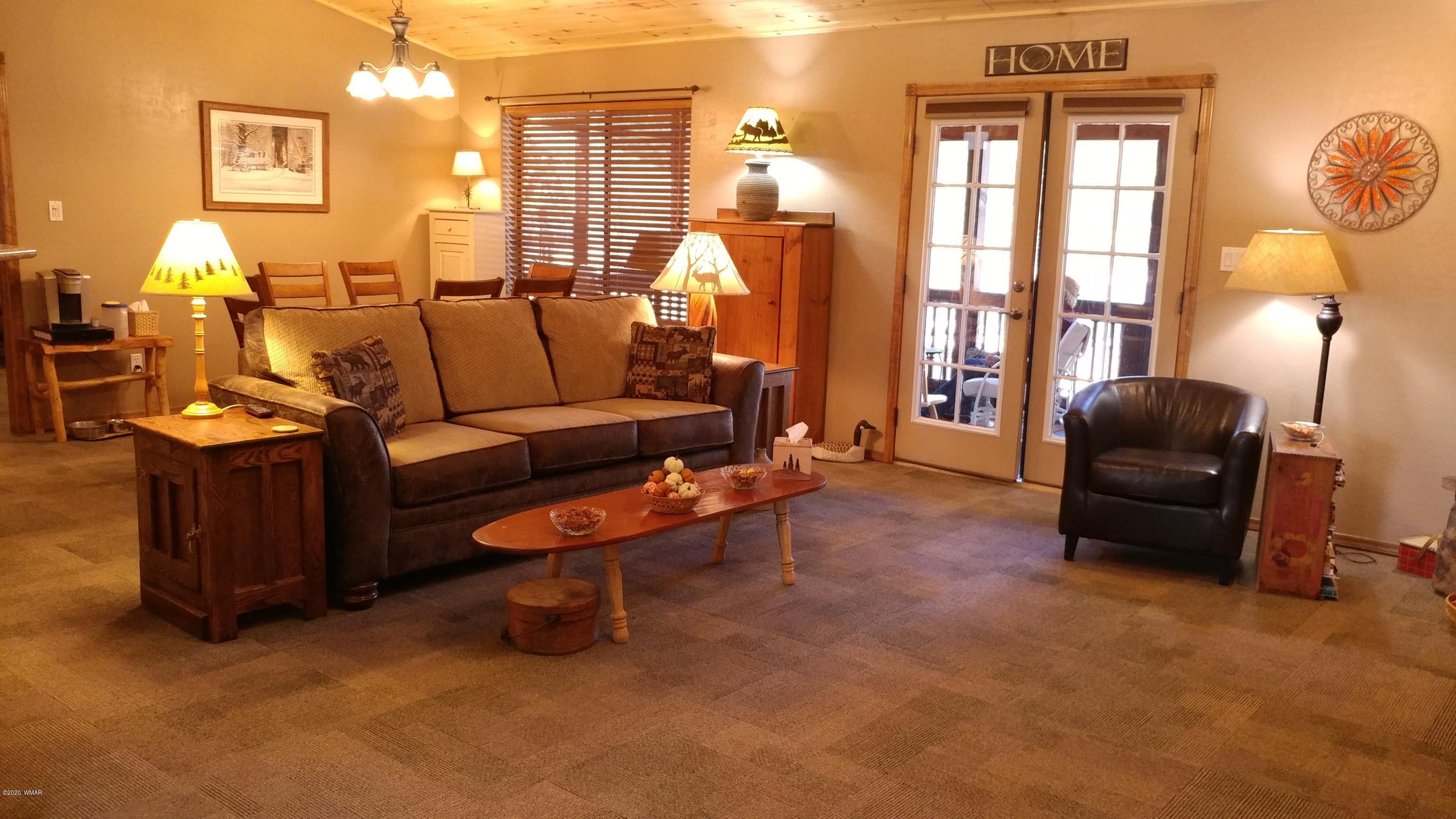 2190 Rimview Trail Overgaard, AZ 85933 - Photo 6 of 45 a living room with furniture a fireplace and a chandelier