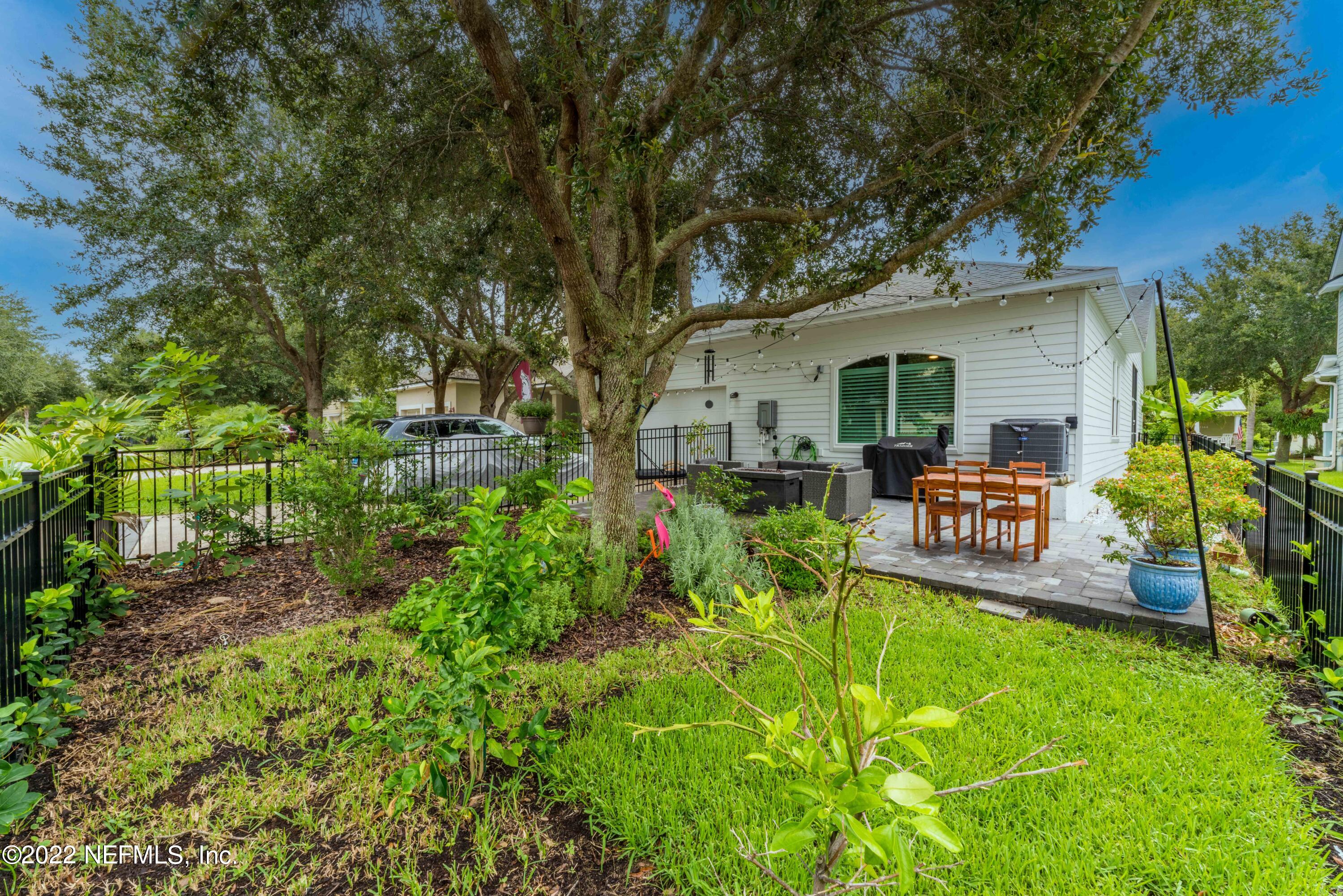 1145 Overdale Road St. Augustine, FL 32080 - Photo 49 of 85 a view of a backyard with table and chairs potted plants and large tree