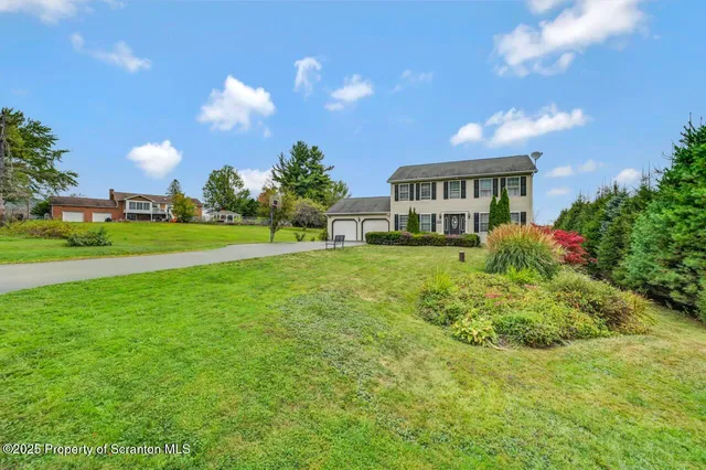 a view of a house with a big yard and potted plants