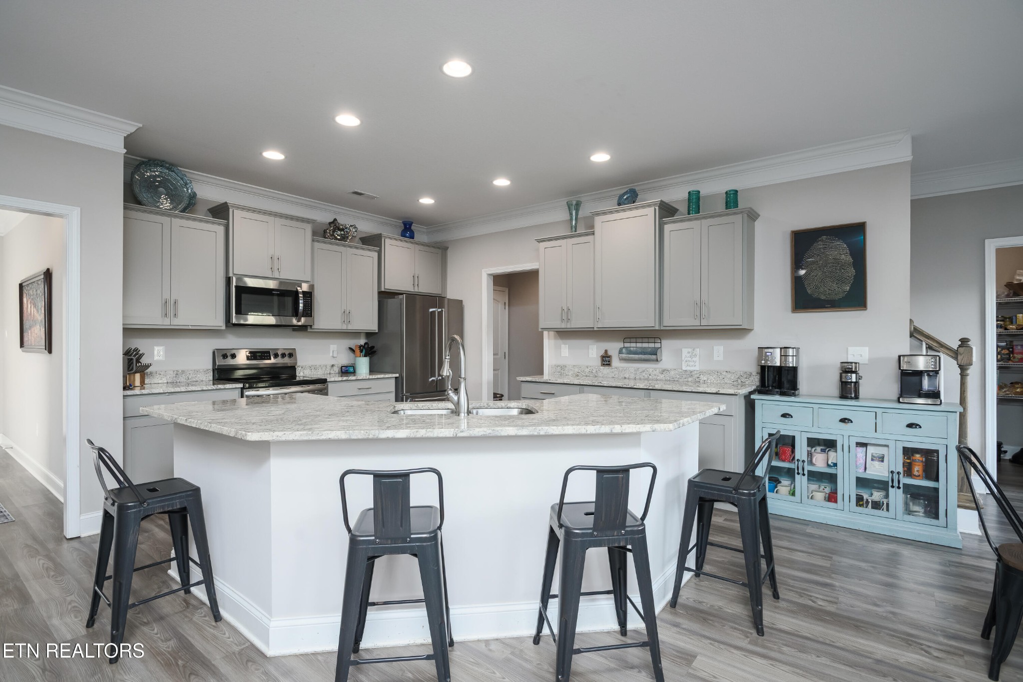 8232 Zodiac Lane Powell, TN 37849 - Photo 5 of 22 a kitchen with stainless steel appliances granite countertop a stove a sink a microwave a refrigerator with white cabinets and wooden floor