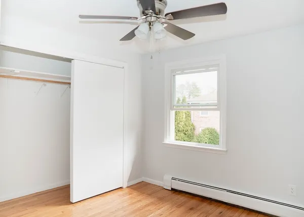 an empty room with a window and a ceiling fan