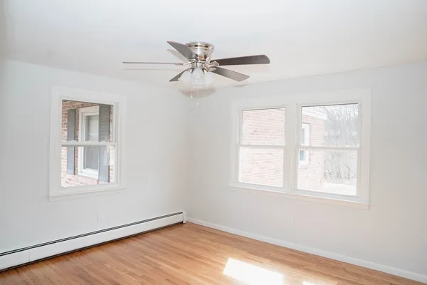 a view of a big room with wooden floor and windows in a room