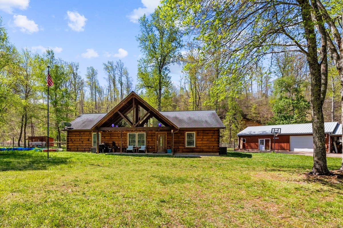 13631 Birdsong Road Holladay, TN 38341 - Photo 19 of 67 a front view of a house with a garden and trees