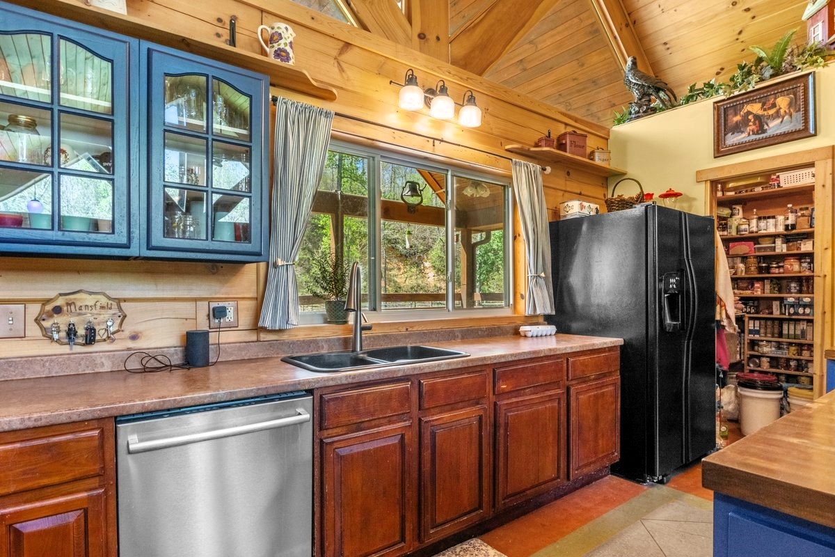 13631 Birdsong Road Holladay, TN 38341 - Photo 28 of 67 a kitchen with stainless steel appliances granite countertop a sink and a refrigerator