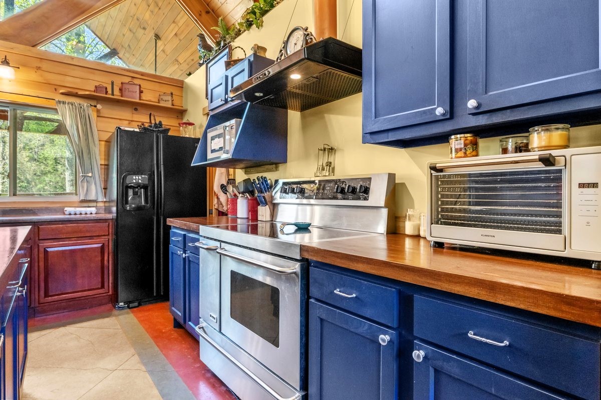 13631 Birdsong Road Holladay, TN 38341 - Photo 29 of 67 a kitchen with stainless steel appliances granite countertop a stove and a refrigerator