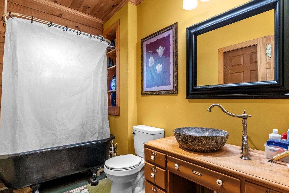 13631 Birdsong Road Holladay, TN 38341 - Photo 39 of 67 a bathroom with a sink a toilet and shower curtain