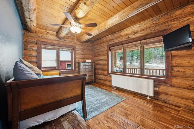 a living room with a table wooden floors and a flat screen tv