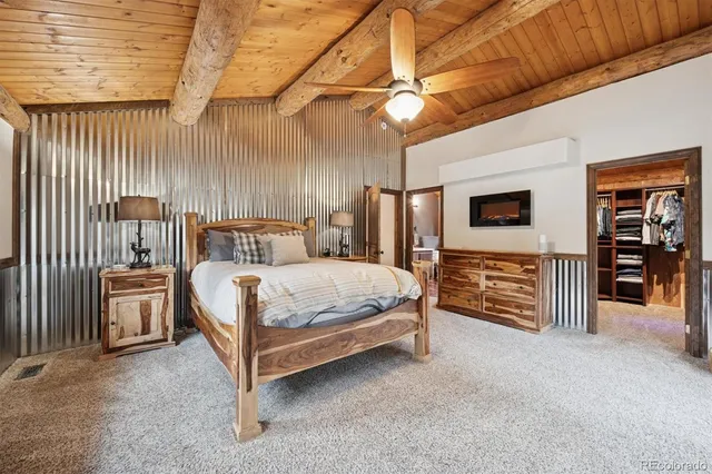 a bed sitting in a spacious bedroom next to a window