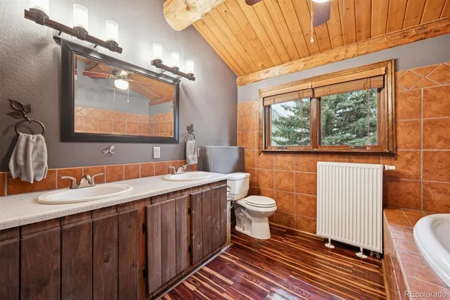 a bathroom with a double vanity sink toilet and a tub