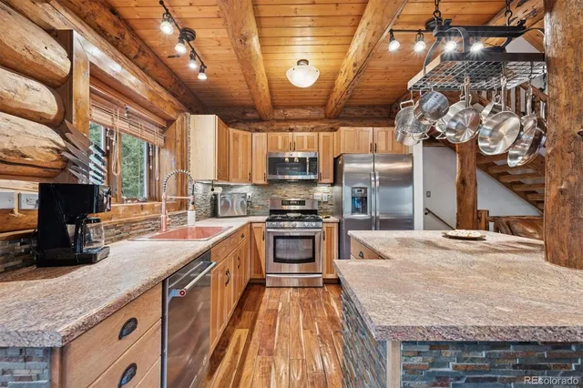 a kitchen with stainless steel appliances granite countertop a stove sink and cabinets