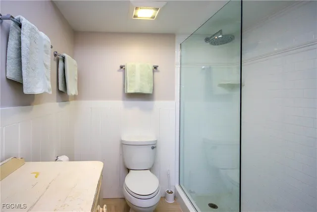 a white toilet sitting next to a bathroom sink and vanity