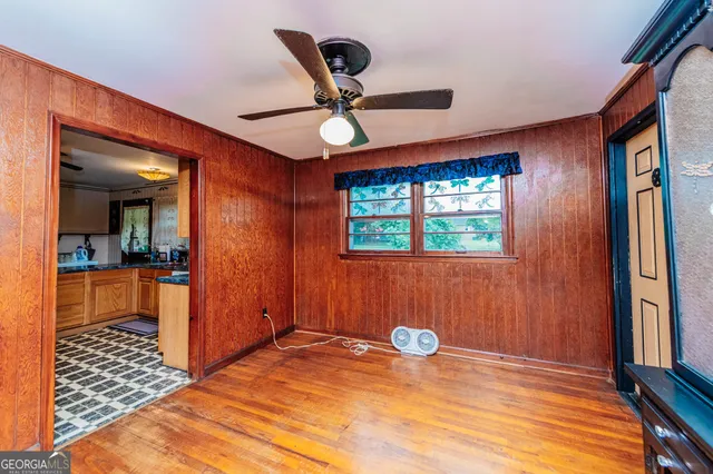 a view of a livingroom with wooden floor and a ceiling fan