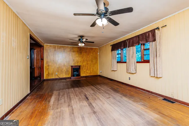 a view of an empty room with wooden floor