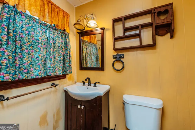 a bathroom with a toilet sink and mirror