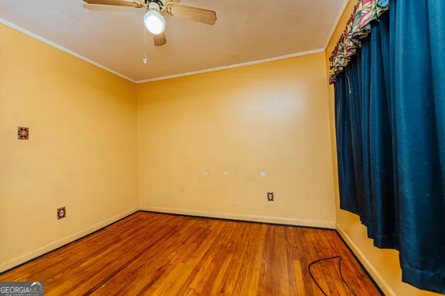 a view of a room with wooden floor and fan
