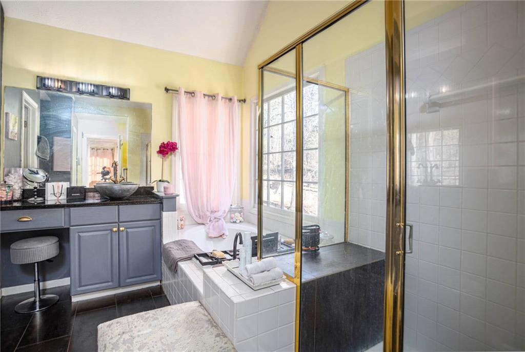 655 Scenic View Stone Mountain, GA 30087 - Photo 28 of 41 a bathroom with a granite countertop sink mirror and a bathtub