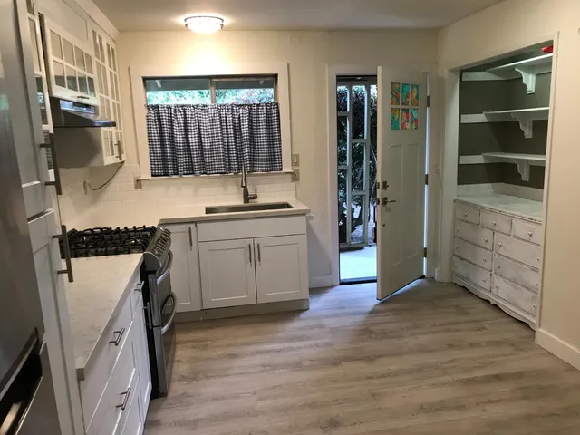 a kitchen with a sink and wooden floor