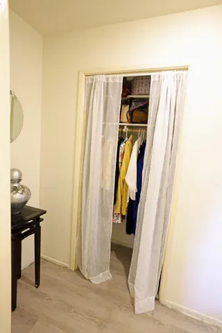 a view of walk in closet with clothes and shoes