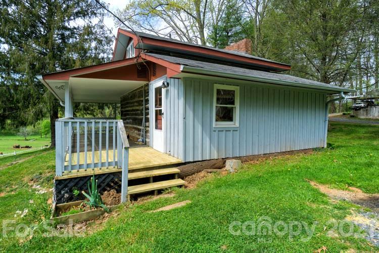 4900 Crabtree Mountain Road Clyde, NC 28721 - Photo 2 of 33 a small house with a small yard plants and large tree