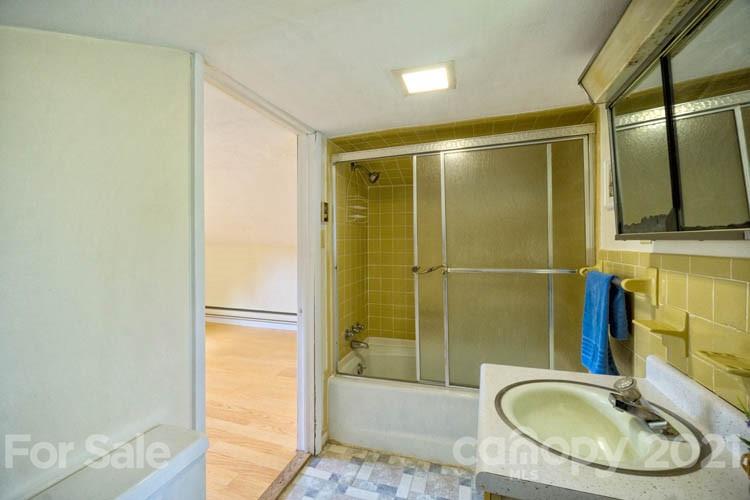 4900 Crabtree Mountain Road Clyde, NC 28721 - Photo 17 of 33 a bathroom with a sink a shower and a mirror