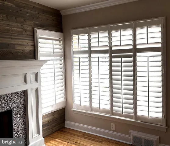 a view of an empty room with a fireplace and a window