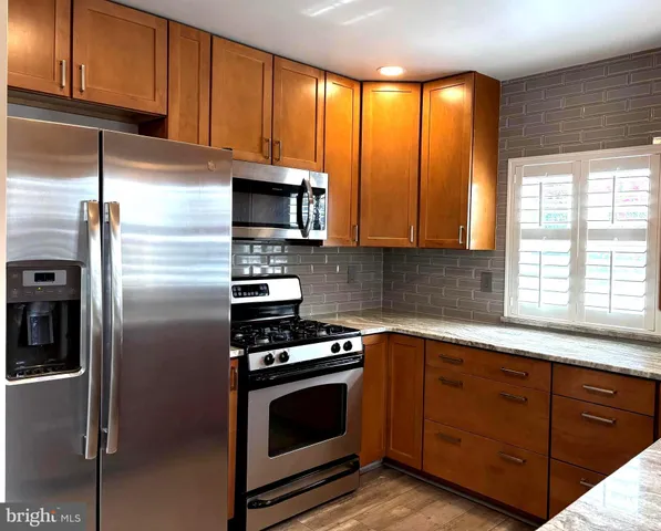 a kitchen with a sink a microwave a refrigerator and cabinets