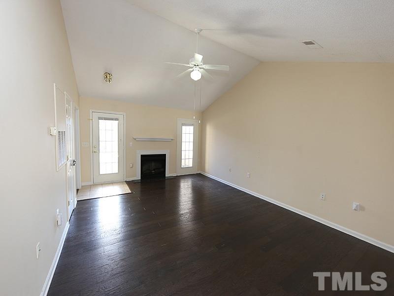 11370 Involute Place, Unit 105 Raleigh, NC 27617 - Photo 3 of 15 an empty room with wooden floor fireplace and windows