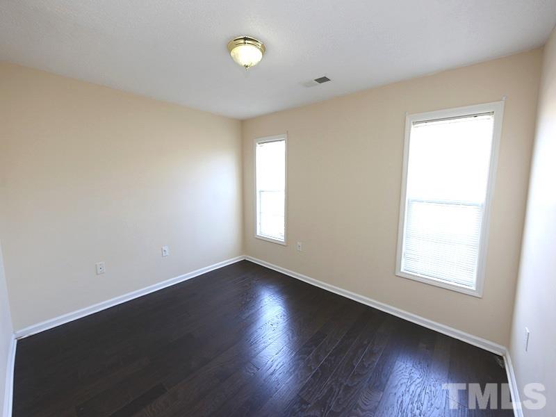 11370 Involute Place, Unit 105 Raleigh, NC 27617 - Photo 5 of 15 an empty room with wooden floor and windows