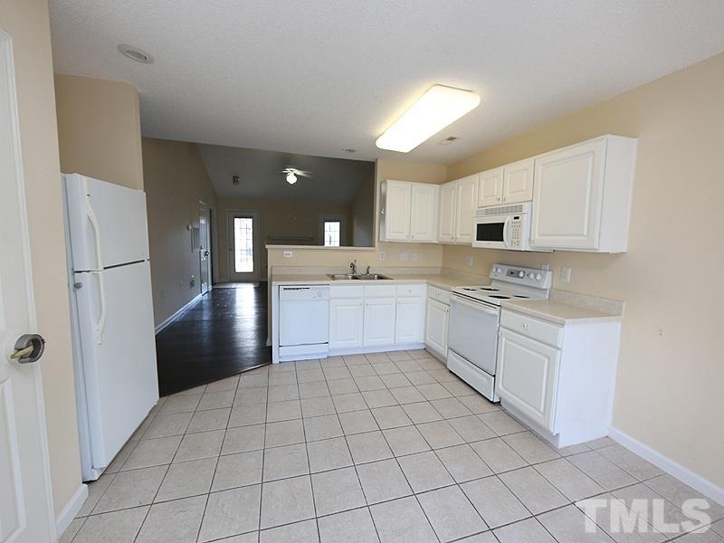11370 Involute Place, Unit 105 Raleigh, NC 27617 - Photo 7 of 15 a large white kitchen with cabinets and stainless steel appliances
