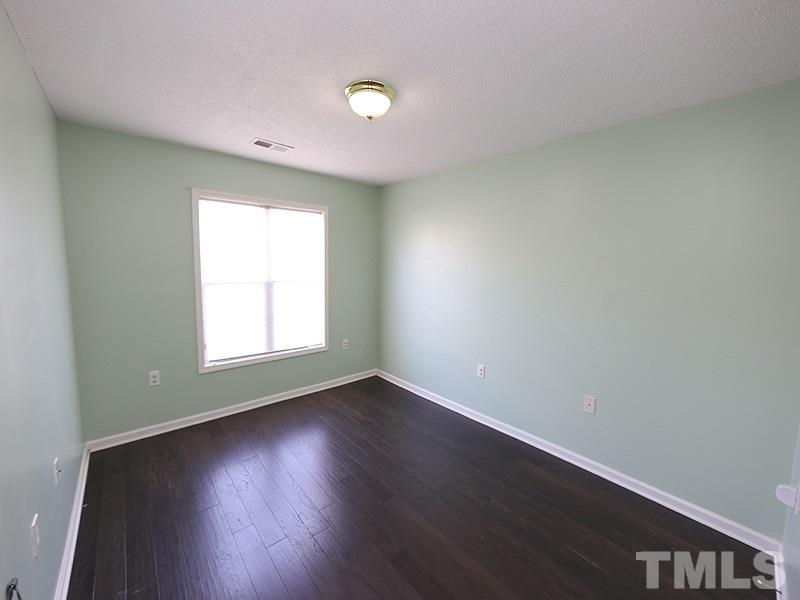 11370 Involute Place, Unit 105 Raleigh, NC 27617 - Photo 9 of 15 an empty room with wooden floor and windows