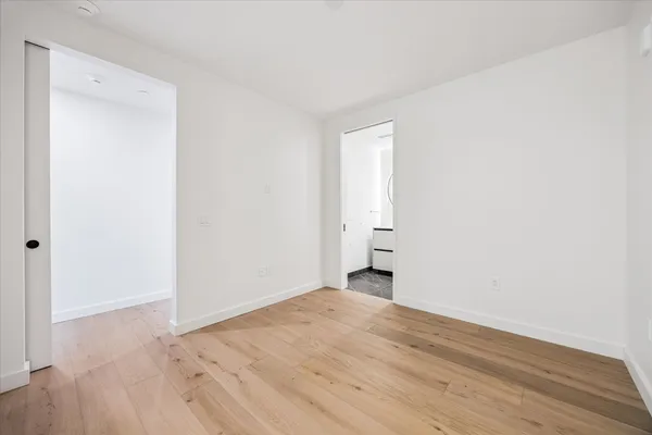 a view of a room with an empty space and wooden floor
