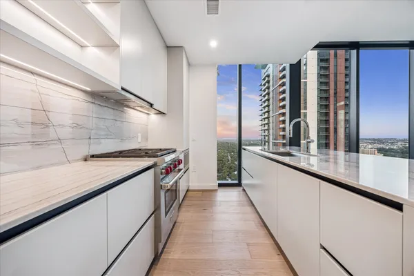 a kitchen with stainless steel appliances granite countertop a sink and a wooden floors